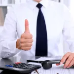 Audit and insurance services close-up of businesswoman showing ok sign while making report calculating or checking balance